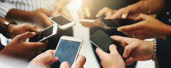 A circle of people with phones in their hands.