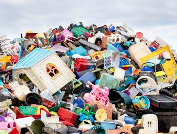 Many pieces of discarded plastic, ranging from baskets to a play house.